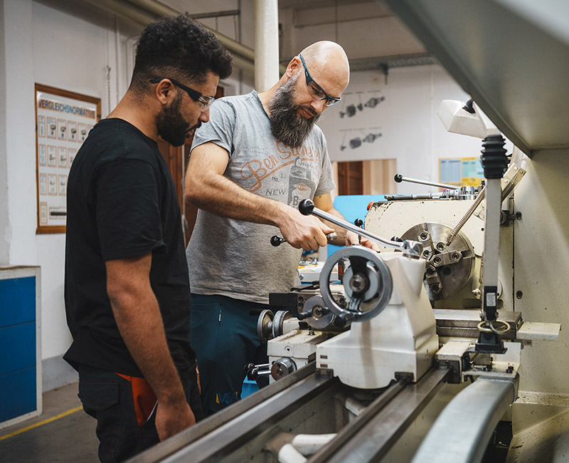 Ausbilder erklärt die Arbeit in der Metallwerkstadt